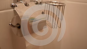 Child Hands Unwind Piece of Toilet Paper, Tearing Off a From Roll