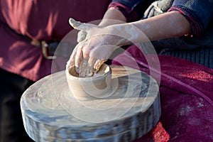Child hands working with the ceramic clay wheel