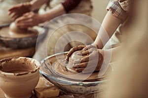 Child hands working on pottery wheel at workshop