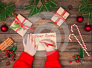 Child hands write letter to Santa. Christmas background. Concept of New year and Christmas. Top view