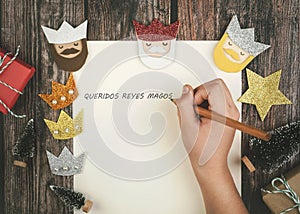 Child hands writing letter to the three kings of orient.Christmas concept background