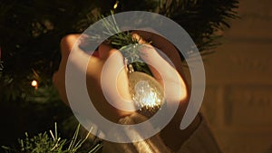 Child hanging bauble on Christmas tree, decoration for festive season, closeup