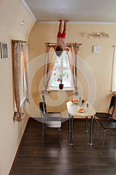 Child hanging up side down in kitchen