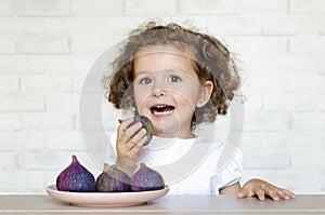 Child happily eat fresh figs.