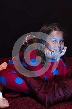 Child with happy face among pillows and blankets