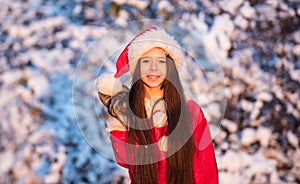 Child happy girl outdoors snowy nature. Merry christmas. Happy childhood concept. Happiness and joy. Kid santa hat