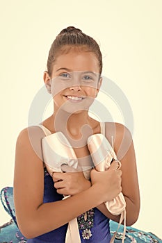 Child happy holds ballet shoes important attribute excellent ballerina. Girl ballerina holds pointe shoes in hand white