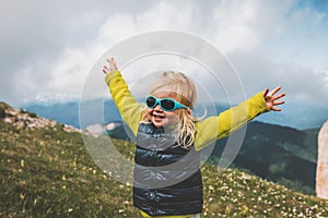 Child happy raised hands walking in mountains travel family vacations lifestyle