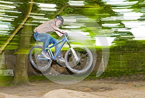 Child has fun jumping with the bike over a ramp