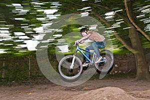 Child has fun jumping with the bike over a ramp