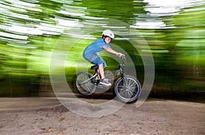 Child has fun jumping with the bike over a ramp