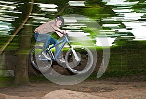 Child has fun jumping with the bike over a ramp