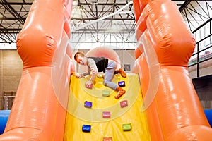 Child has fun jumping in an inflatable castle at a children`s fair