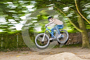 Child has fun jumping with thÃ© bike over a ramp