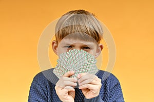 The child has playing cards in front of his face. Gambling anonymity concept photo