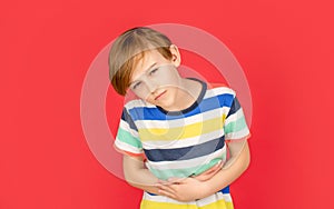 Child has stomachache with food poisoning. Child holding hands on belly. Stomach pain. Teen boy with stomachache. Child