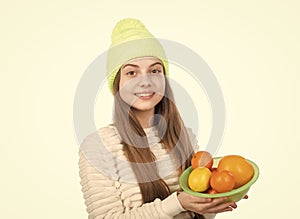 child in hat and sweater hold citrus fruits. autumn fashion style. warm clothes.