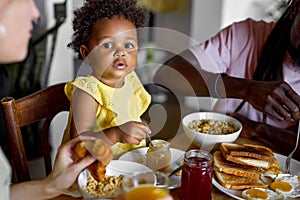 Child having breakfast. Kid girl eating poridge with fruit. Little girl at dining table in kitchen