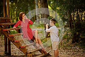 Child having fun, blowing dandelions. Childhood happiness concept, boy playing with dandelions