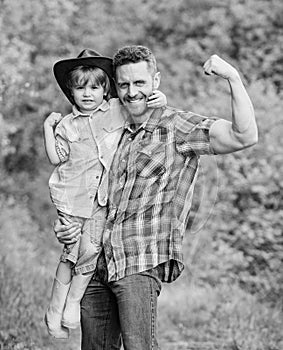 Child having fun cowboy dad. Rustic family. Growing cute cowboy. Small helper in garden. Little boy and father in nature
