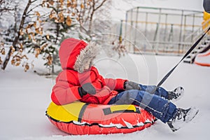 Child having fun on snow tube. Boy is riding a tubing. Winter fun for children