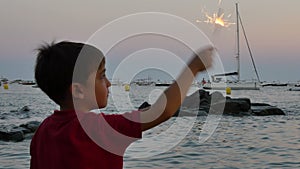 Child having fun with a sparkling flare at sunset