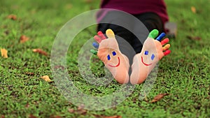 Child having fun in spring park outdoors. Smiley on feet.