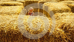 Child in hay bale maze