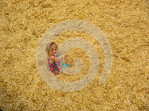 Child in hay stack mound