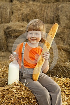 Child on a haystack with bread