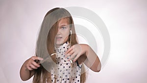 Child with headphones dancing at studio background. Girl listens to music on smartphone. Beautiful cute happy little