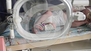 child health, small newborn child lies in pressure chamber connected to an artificial respiration apparatus after an