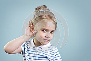 Child with hearing problem on blue background empty copy space. Hearing loss, symptoms and treatment concept