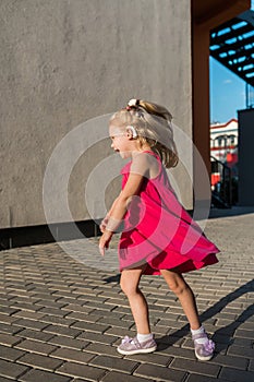 Child with hearing problem and cochlear implant dance in street, deaf kid began to hear. Hearing loss in childhood and