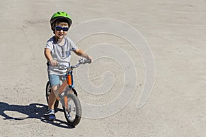 Child in helmet ride balance bike