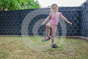 The child helps with scarifying the lawn.