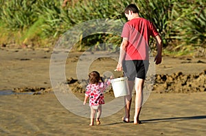 Child helps to carry a heavy bucket photo