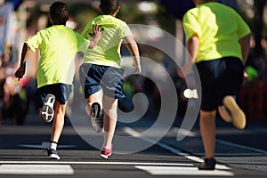 The child helps the weaker runner in the city run