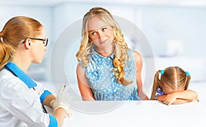 Child with her mother on visit at doctor afraid vaccinations