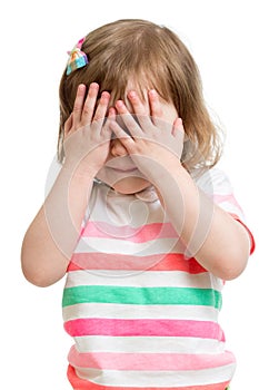 Child hiding face by hands