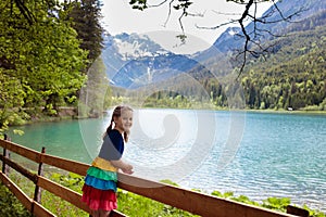 Child hiking in flower field at mountain lake