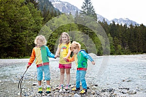 Child hiking in mountains. Kids at river shore.