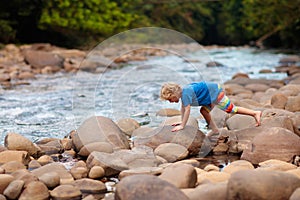 Child hiking in mountains. Kids at river shore