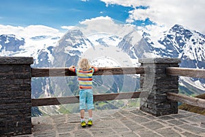 Child hiking in mountains. Kids in snow in spring.