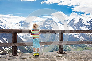 Child hiking in mountains. Kids in snow in spring