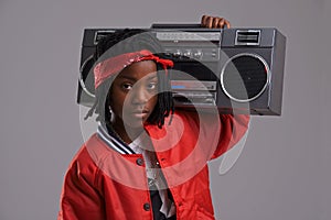 Child, hip hop and portrait with radio for cool music and dance in a studio with urban clothing. Fashion, African kid