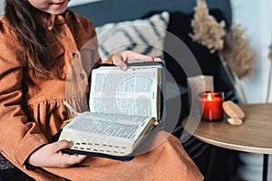 The child in his hands holds the Bible close-up