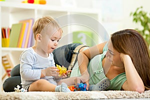 Child and his mom play zoo holding animal toys