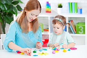 Child with his mother sculpts from clay