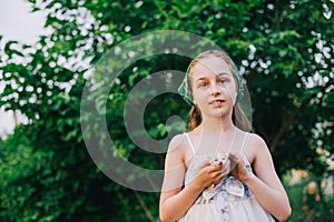 Child holding baby cat. Kids and pets. Little girl hugging cute little kitten in summer garden.Domestic animal in family